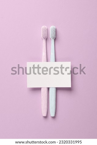 Toothbrushes with a card on a purple pastel background