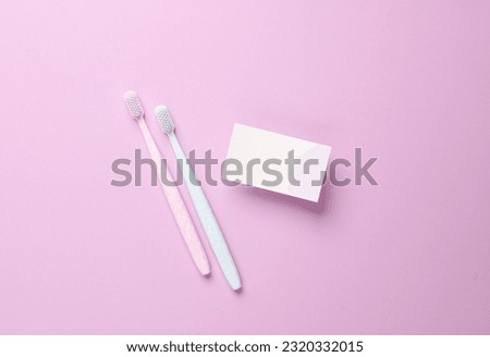 Toothbrushes with a card on a purple pastel background