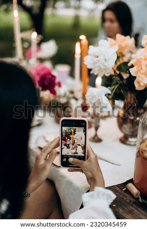 take pictures on the phone of a decorated table for a picnic party. take photos on a smartphone. details of a decorated picnic area