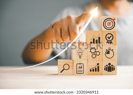 Businessman's hand stacking wood blocks, symbolizing the relationship between business strategy, Action plan, and project management. Copy space available for professional presentations.