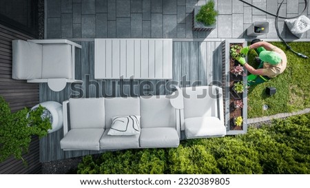 Top View of Professional Landscaper Planting Ornamental Flowers Into Planter at the Terrace of Modern Backyard Garden. Landscaping Theme. Royalty-Free Stock Photo #2320389805