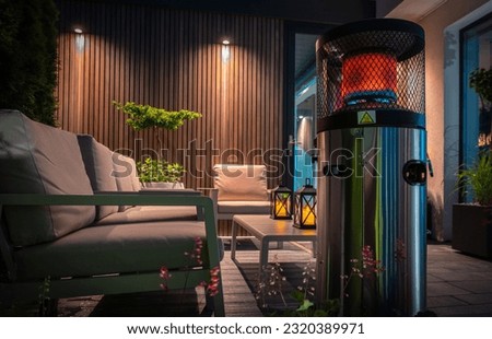 Modern Cozy Patio with Gas Heater Warming the Area During Cold Summer Evening. Residential Backyard Design. Royalty-Free Stock Photo #2320389971