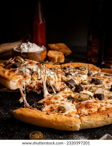 This is the perfect pizza picture that showcases the essence of elegance and premium dining. The dark and moody board beautifully presents the exquisite pizza in all its glory.