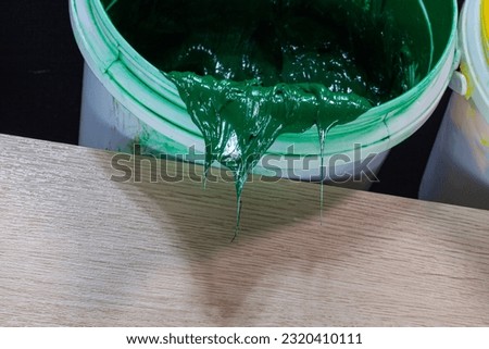 
Green paint dripping from white barrel.
plastisol ink is used for printing on fabrics because it is durable,
 easily cured and can be stretched without cracking or becoming distorted.
