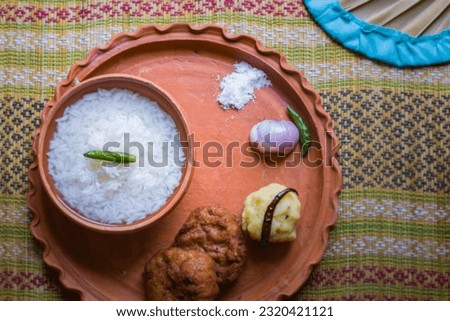 Panta bhat or pakhala or fermented rice soup with water is served in clay bowl with raw onion and green chilli. It is traditional staple cool food of Bengal and odisha during summer season of boisakh. Royalty-Free Stock Photo #2320421121