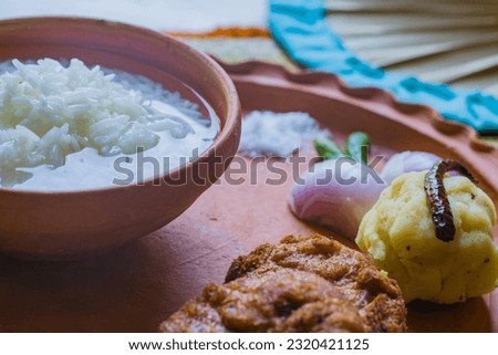 Panta bhat or pakhala or fermented rice soup with water is served in clay bowl with boiled potato, chop, onion and green chilli. It is traditional cool food of Bengal and odisha during summer season. Royalty-Free Stock Photo #2320421125
