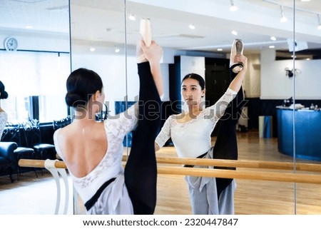 Female ballerina practicing alone in front of a mirror Royalty-Free Stock Photo #2320447847