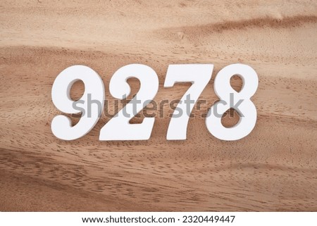 White number 9278 on a brown and light brown wooden background.