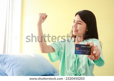 Beautiful Asian patient holding a credit card to pay medical bills. concept of health insurance