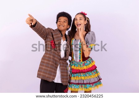 Children in typical clothes from the famous Brazilian party called "Festa Junina" in celebration of São João. Afro boy and white girl celebrating the June party in Brazil
