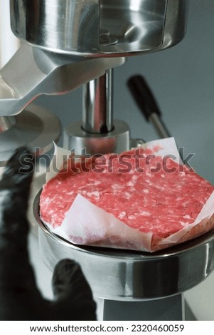 burger press maker in high res. image and isolated with a blurry ends Royalty-Free Stock Photo #2320460059