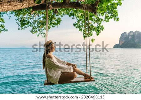 Traveler woman relaxing on swing above Andaman sea Railay beach Krabi, Leisure tourist travel Phuket Thailand summer holiday vacation trip, Beautiful destinations place Asia, Happy dream concept Royalty-Free Stock Photo #2320463115