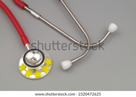 Medical service rating concept. Stethoscope with yellow stars on gray background.