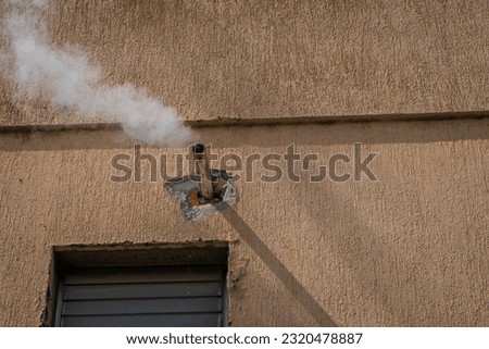 House chimney emitting white smoke Royalty-Free Stock Photo #2320478887