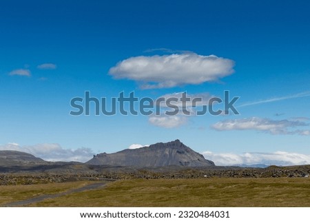 very beautiful and impressive mountains with fields and cloudy sky in peninsula of Snæfellsbær in summer, Iceland.