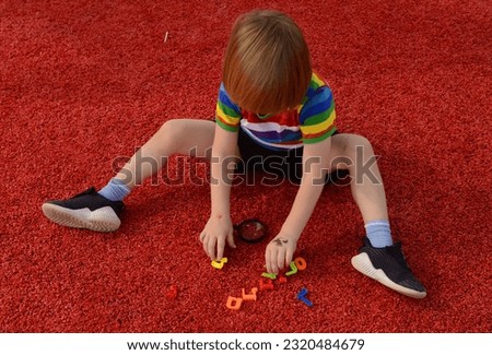 A preschooler plays with the letters of the Hebrew alphabet. The child is learning Hebrew. Ready for school Royalty-Free Stock Photo #2320484679