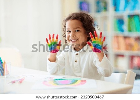 Child drawing rainbow. Paint on hands. Remote learning and online school art homework from home. Arts and crafts for kids. Little boy drawing bright picture. Creative kid playing and studying. Royalty-Free Stock Photo #2320500467