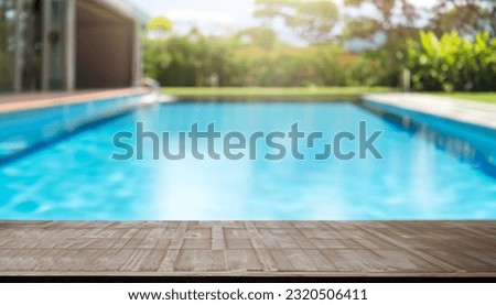 Empty wooden table in front with blurred background of swimming pool Royalty-Free Stock Photo #2320506411