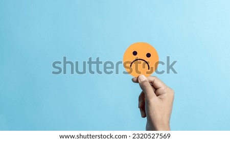 Hand holding sad face negative emotion. emotional intelligence, balance emotion control, mental health assessment, bipolar and depression, mental health concept, personality, therapy healing split. Royalty-Free Stock Photo #2320527569