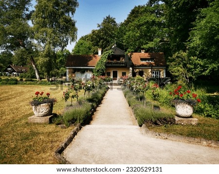 An old, stately farmhouse in Bavaria with a lovingly landscaped garden with lavender and roses.