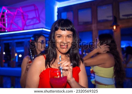 Portrait attractive woman with a glass of alcohol in a nightclub at a night party