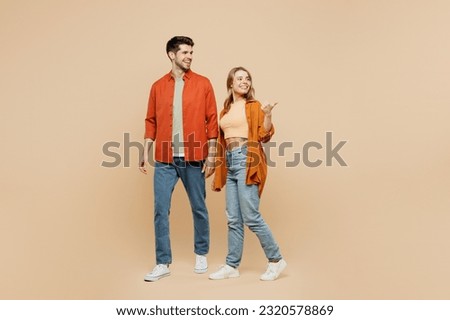 Full body young couple two friends family man woman wear casual clothes together point thumb finger aside indicate on workspace area copy space mock up isolated on pastel plain beige color background Royalty-Free Stock Photo #2320578869