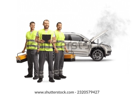 Team of road assistance workers with reflective vests standing in front of a SUV isolated on white background Royalty-Free Stock Photo #2320579427