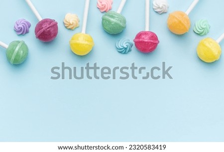 Colorful sweet lollipops and candies over blue background.  Flat lay, top view