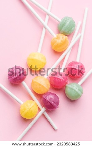 Colorful sweet lollipops over pink background.  Flat lay, top view Royalty-Free Stock Photo #2320583425