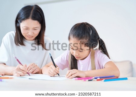 Parent and child playing and drawing in the room