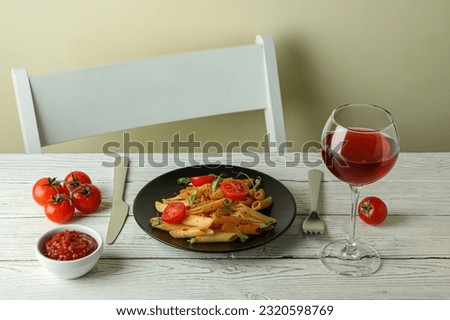 Concept of tasty food with pasta with tomato sauce on white wooden table