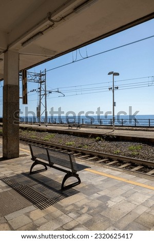 Devia Marina station tracks in Italy. No trains, no people, complete desolation and sadness. Beautiful open sea view, empty bench