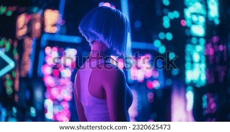 Beautiful Retro-Futuristic Portrait of a Human Gamer Girl Resembling an Android Robot with Artificial Intelligence, Travelling in Modern City with Neon Lights and Colorful Cyberpunk Vibe Royalty-Free Stock Photo #2320625473