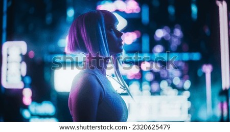 Cinematic Arc Shot of a Stylish Young Cosplay Model with Blue Hair Wandering Around a Futuristic Cybernetic City with Neon Lights. Young Excited Female in a Cyberpunk Virtual Reality Royalty-Free Stock Photo #2320625479