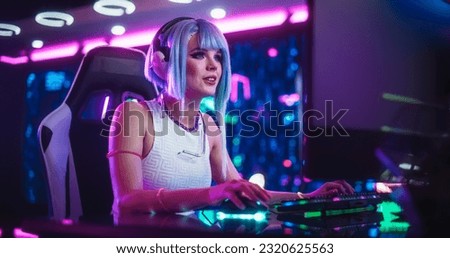 Happy Cosplay Girl Chats Online with Friends on Computer, Surrounded by Cyberpunk Style Background. Concept of Internet Streaming, Video Gaming eSports and Social Networks