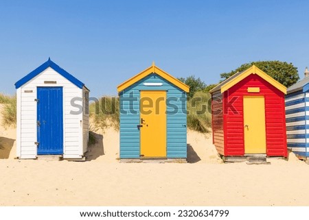 Colourful wooden beach huts on the sandy beach in Southwold, Suffolk. UK Royalty-Free Stock Photo #2320634799