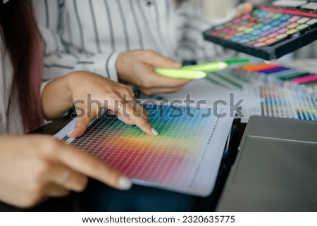 graphic designer working with laptop and color swatch. creative man using digital tablet at modern office. 
