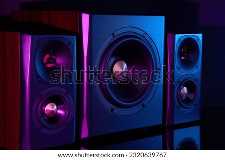 Multimedia acoustic sound speakers with neon lighting. Sound audio system with two satellites and subwoofer on dark background. Royalty-Free Stock Photo #2320639767