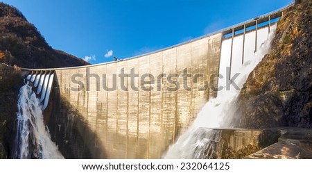 Dam of Contra Verzasca Ticino, Switzerland: spectacular waterfalls from the overflow of the lake over the dam Royalty-Free Stock Photo #232064125