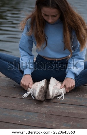 Young girl is doing yoga near lake