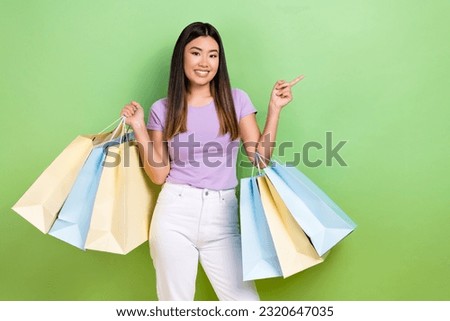 Photo portrait of pretty japanese korean young girl shopping bags empty space wear trendy purple outfit isolated on green color background