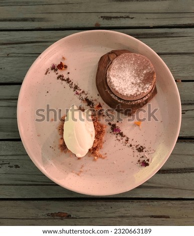 Deserts. Vanilla Ice Cream. On top of White Ceramic Plate with Wood Table background. Top Angle.