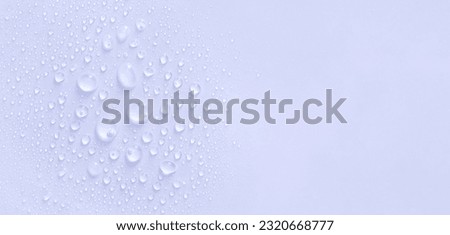 water drops of transparent gel serum on a pastel purple background