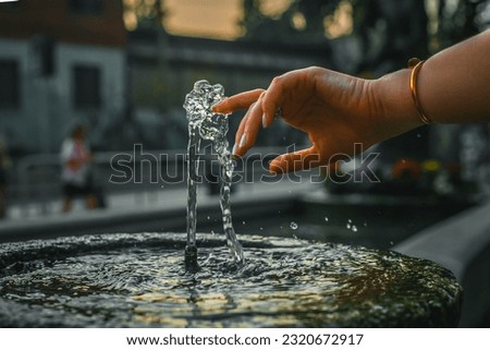 A jet of a street drinking fountain in Milan, Italy. Drinking fountain in a stone bowl outdoors. Close-up photo. Full frame.