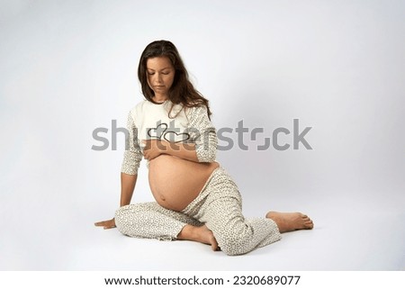 Young pregnant woman with big belly. Happy pregnant woman on white background with copy space. Pregnancy, motherhood, people and expectation concept