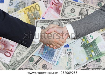 Business handshake over bunch of money in background