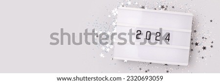 Banner with 2024 numbers and shiny silver stars confetti on a blue background. New Year festive concept.