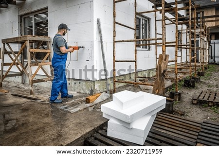 Worker makes building insulation saves energy with styrofoam. Industrial theme Royalty-Free Stock Photo #2320711959