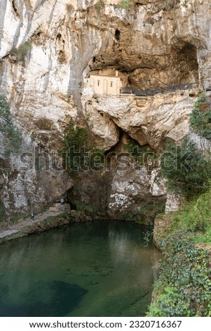 Vertical view of the Santuario de nuestra señora de Covadonga in Asturias, chapel of medieval origin built in stone in the rock of the mountain and underneath a lake signed by water from the mount