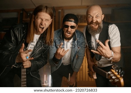 Crazy rock band artists portrait, funky musicians gesturing rock-and-roll sign